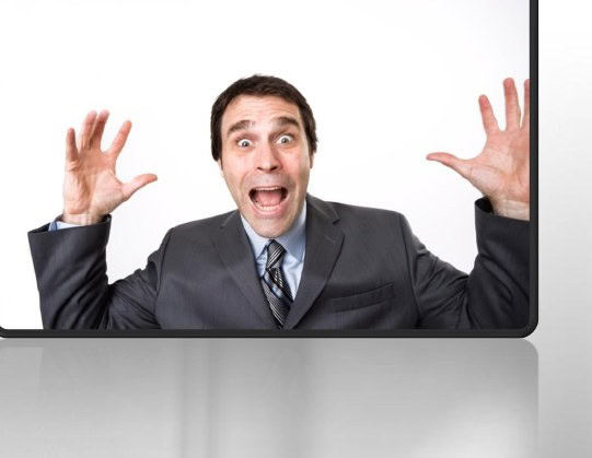 Gestor de fincas asustado viendo un programa para administradores de fincas en la pantalla.